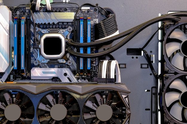 An interior view of a partially assembled PC, showcasing the motherboard with CPU and RAM installed, and the power supply unit connected with various cables. The focus is on the intricate connections and the overall organization of the components within the case.